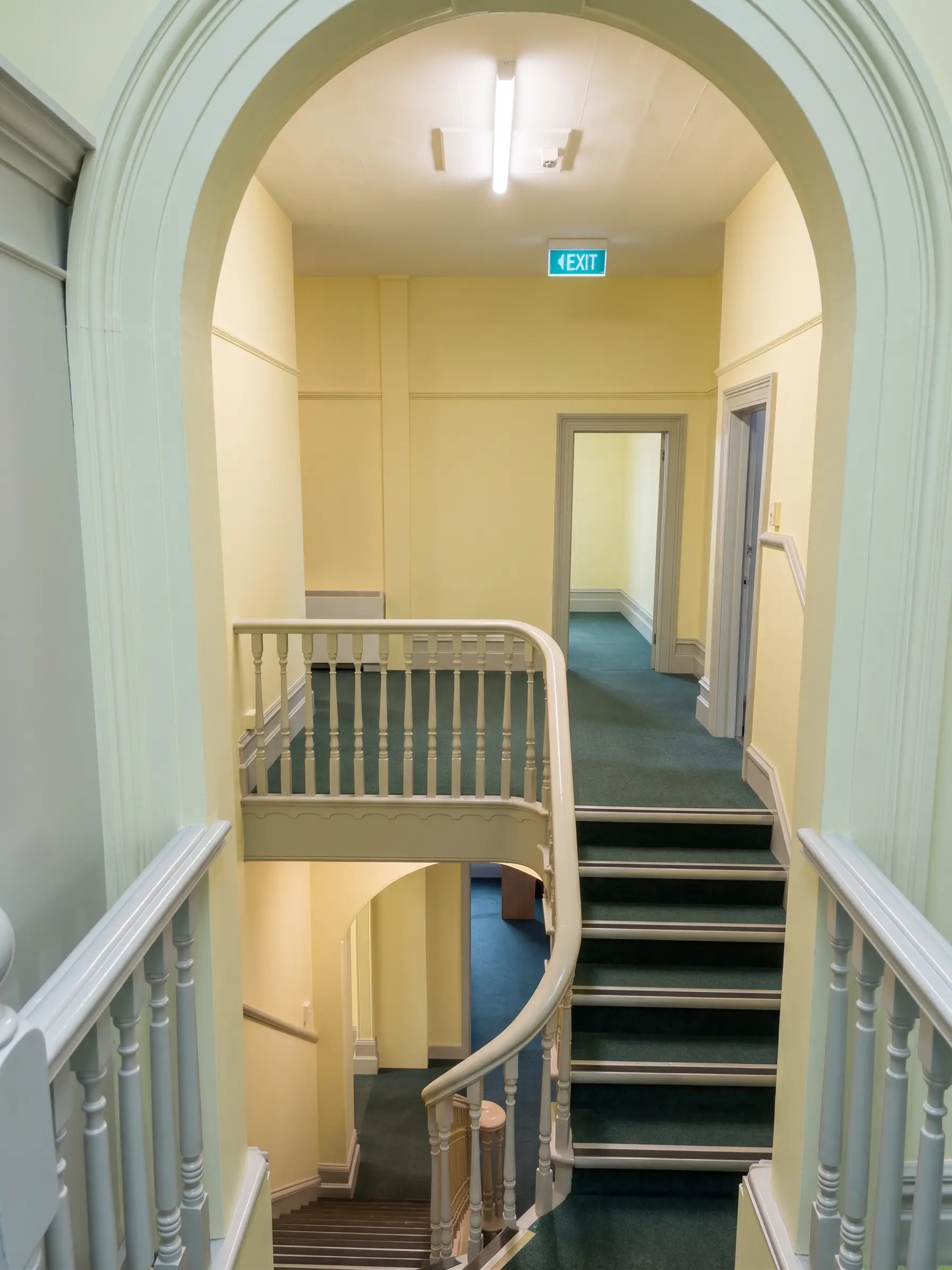 Painted stairway and landing area showing finished commercial interior work with period detailing